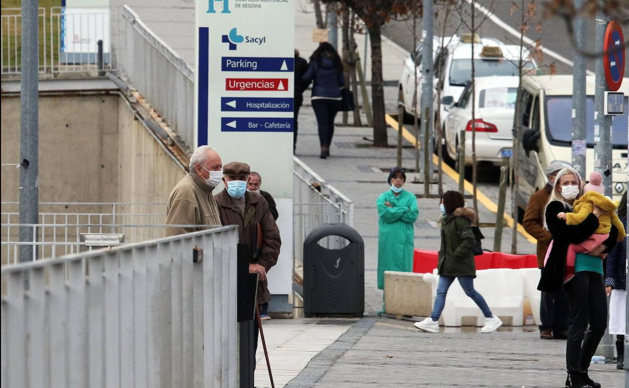 Usuarios y sanitarios en las inmediaciones de la entrada principal al Hospital General durante la pandemia. 