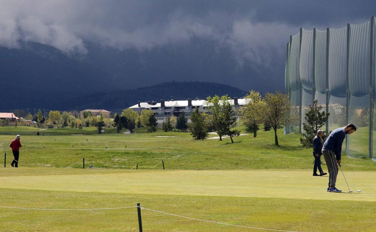 Socios de La Faisanera juegan este miércoles en el campo de golf, con algunas de las viviendas de Quinta Real y la sierra de Guadarrama al fondo. 