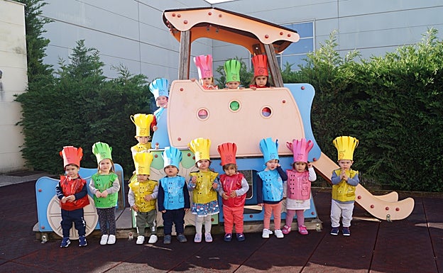 Los niños posan con su gorro y delantal de cocinero al finalizar el taller