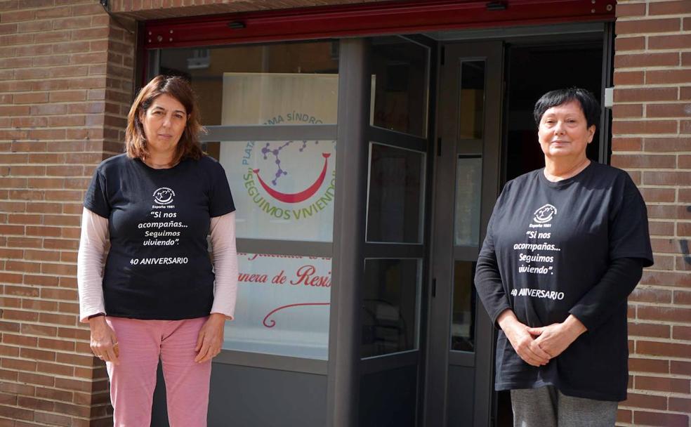 Carmen Cortés (izquierda) y Mercedes García, ante la puerta de su asociación en el barrio madrileño de Vallecas. 