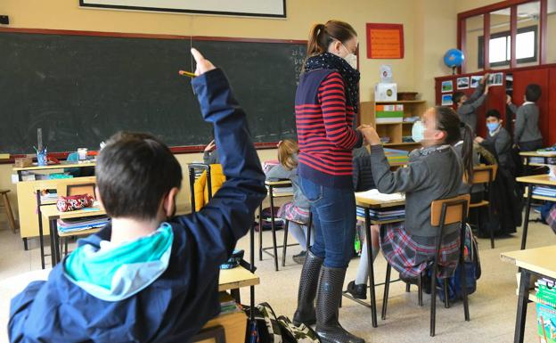 Un niño levanta la mano en clase. 