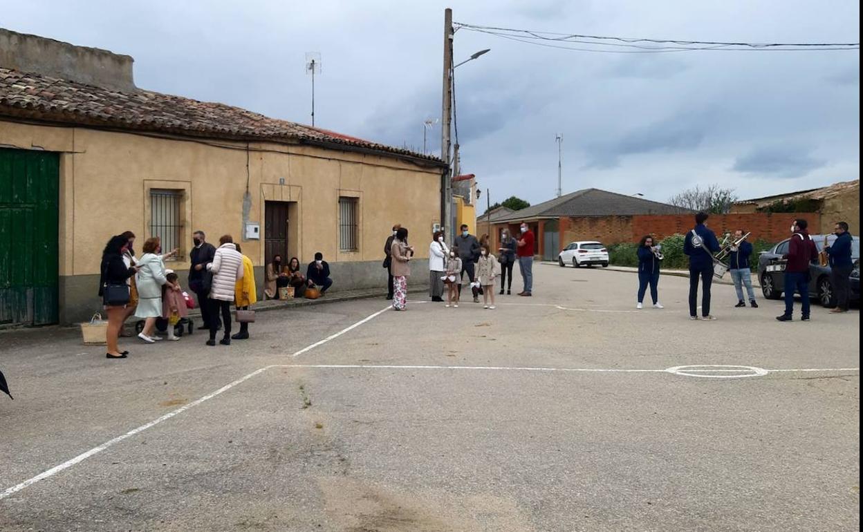 Un grupo de vecinos en una calle del pueblo acompañados por una charanga.