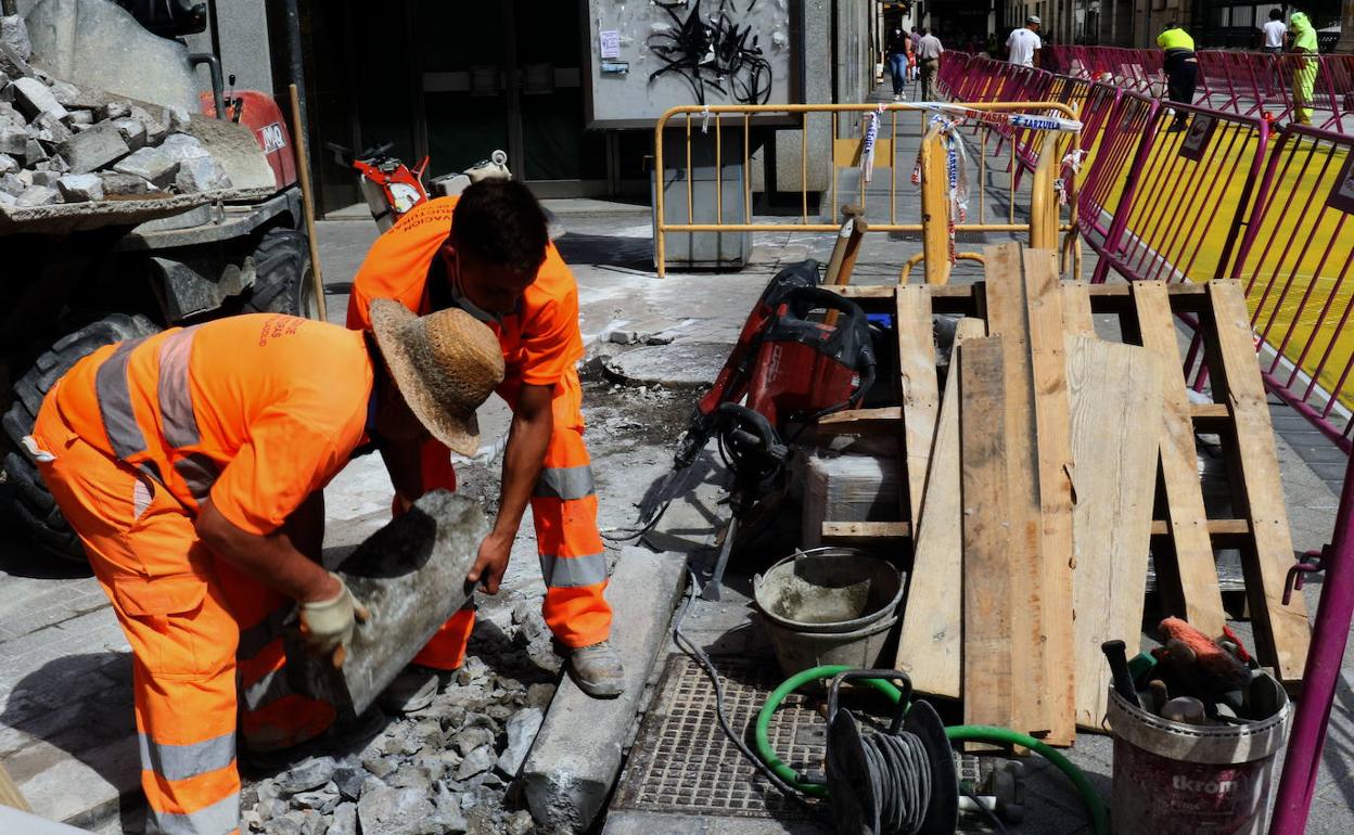 Varios operarios trabajan en las obras de una calle de Valladolid. 