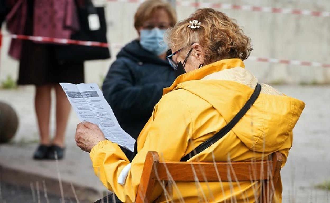 Una mujer lee información sobre qué puede pasar después de ponerse la vacuna .