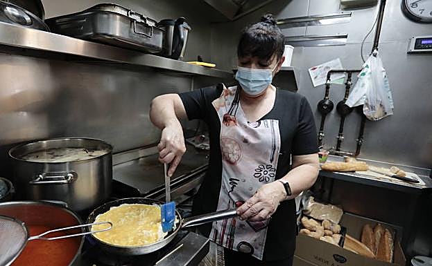 La cocinera Chus Ares Ferrero, del Villa del Prado Café Bar, despega bien por los lados de la sartén la tortilla antes de darla la vuelta. 