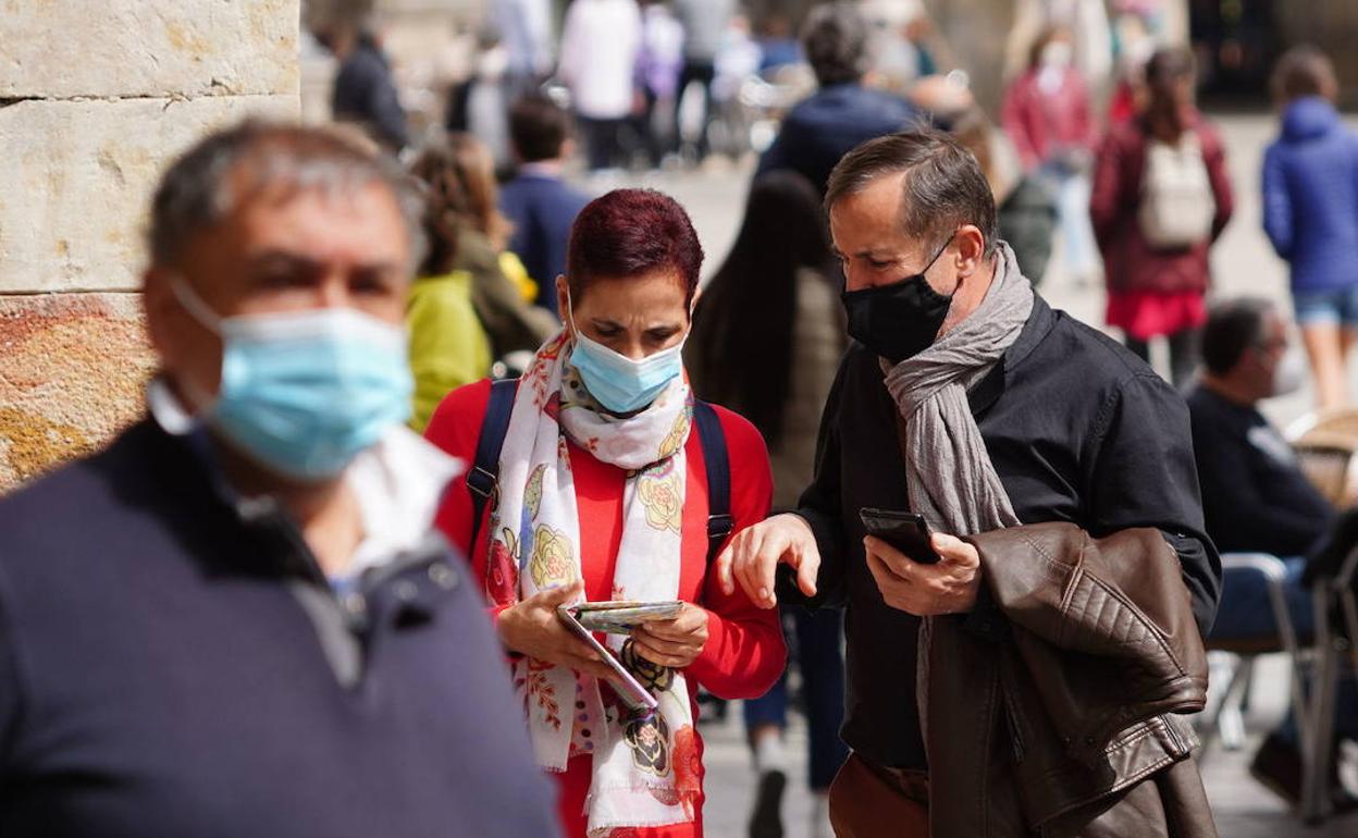 Dos turistas consultan el móvil mientras pasean por Salamanca. 