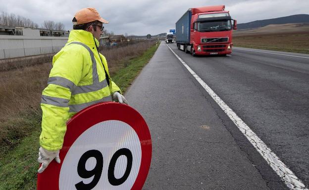 Un operario cambia la señalización en una carretera convencional tras el último recorte de velocidad