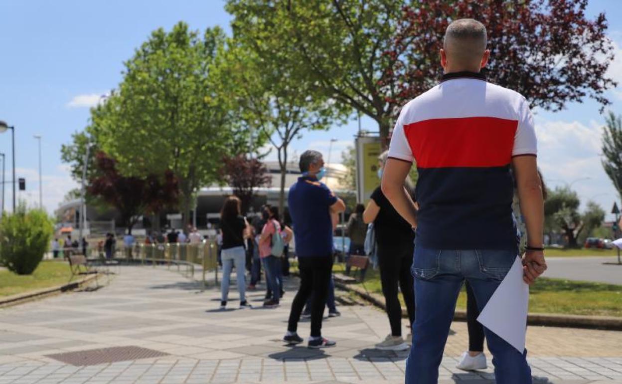 Una persona, con un cosnentimiento para recibir la vacuna de AstraZeneca, espera en la cola del Multiusos. 