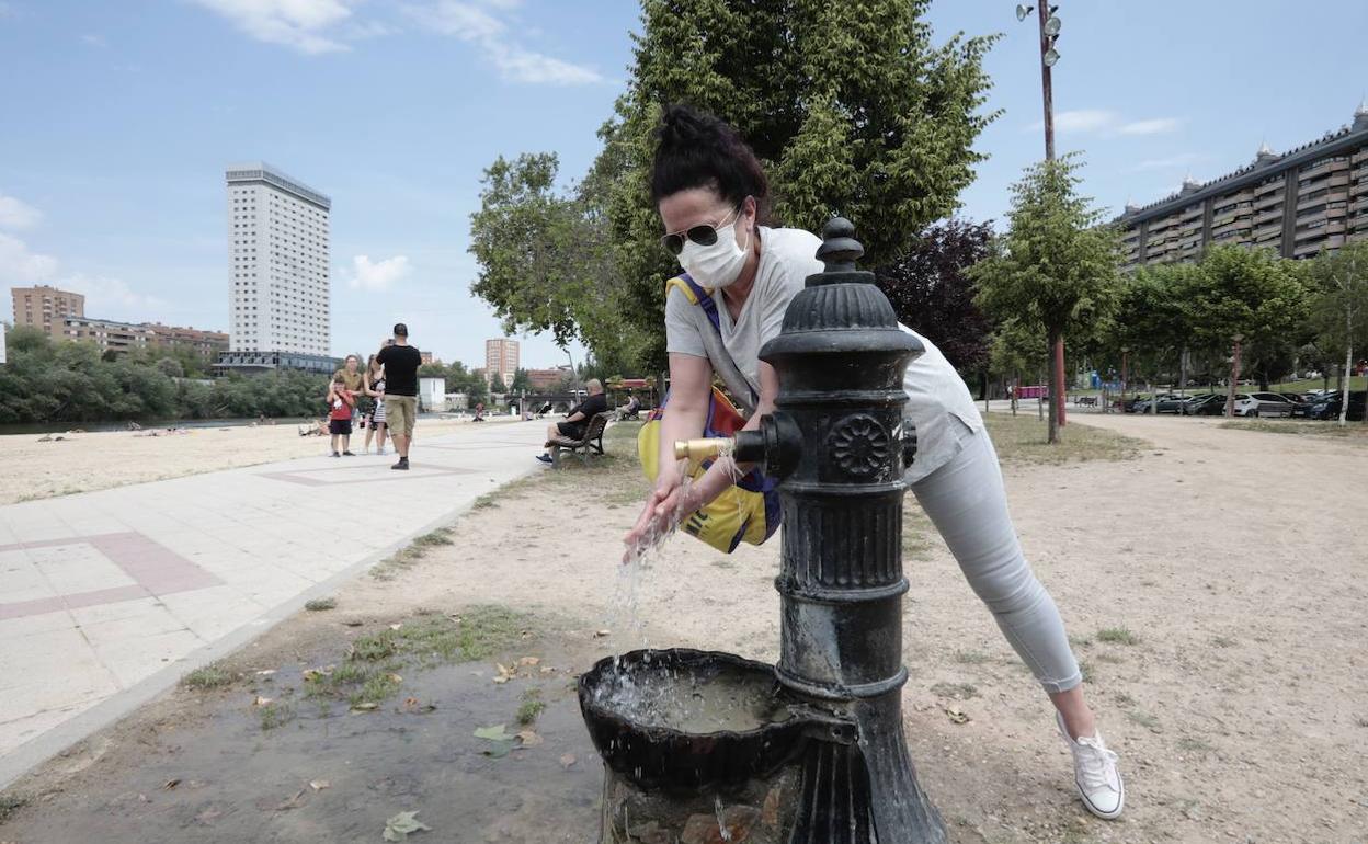 Una mujer se refresca en una fuente de la zona de las Moreras de Valladolid. 