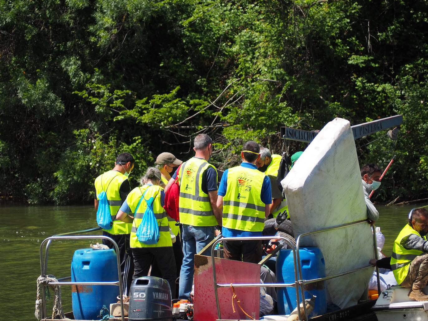 Los voluntarios, con algunos de los enseres retirados del río y de la ribera del Pisuerga. 