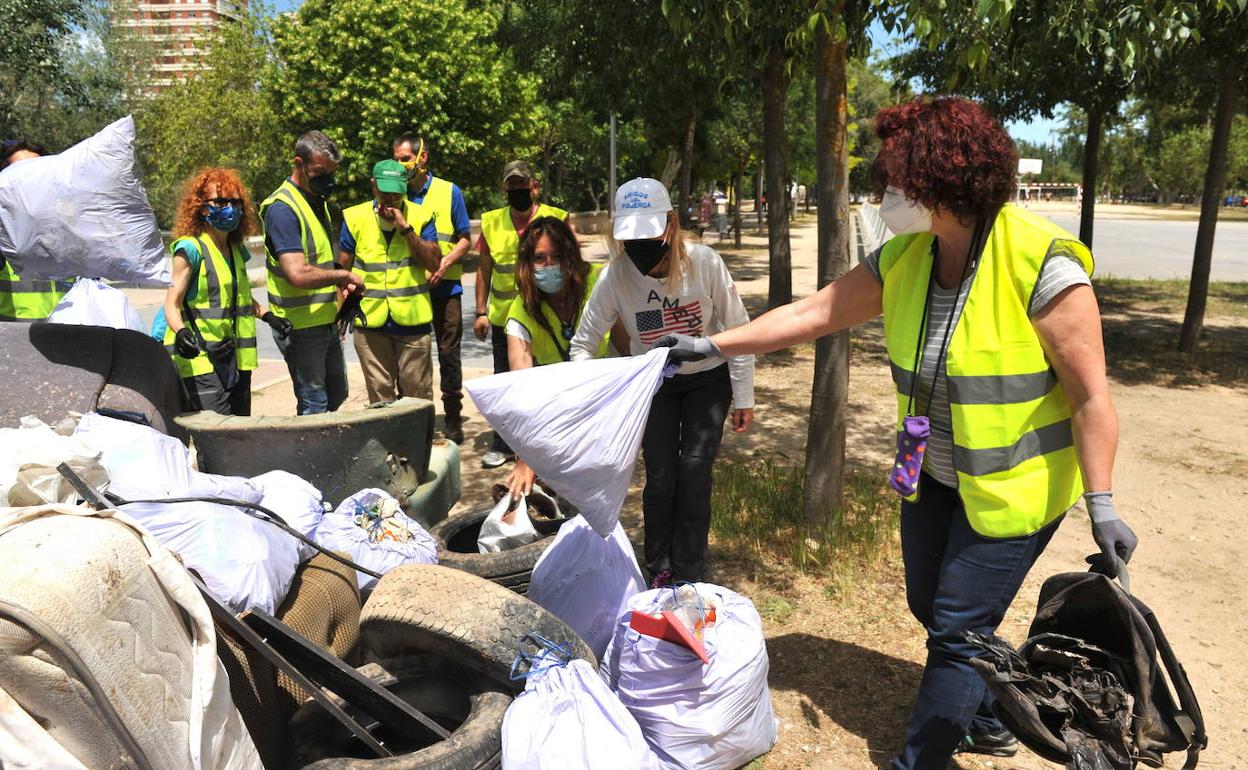 Los voluntarios tiran los enseres y desperdicios recogidos de las riberas del Pisuerga. 