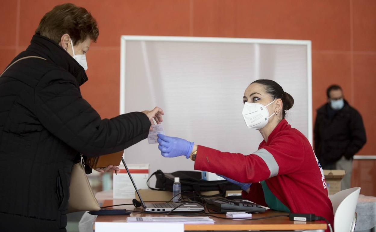 Una sanitaria atiende a una mujer en el centro de vacunación instalado en el Miguel Delibes.