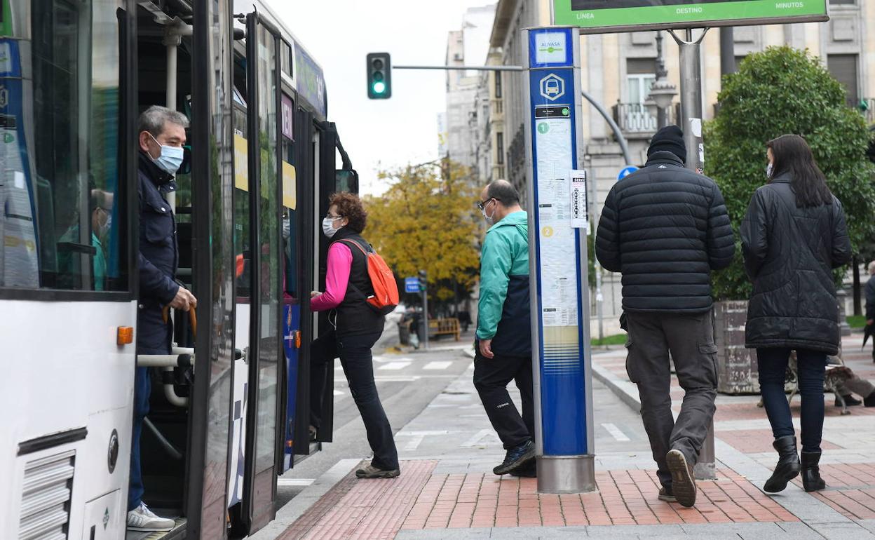 Varias personas suben y bajan de un autobús de Auvasa. 