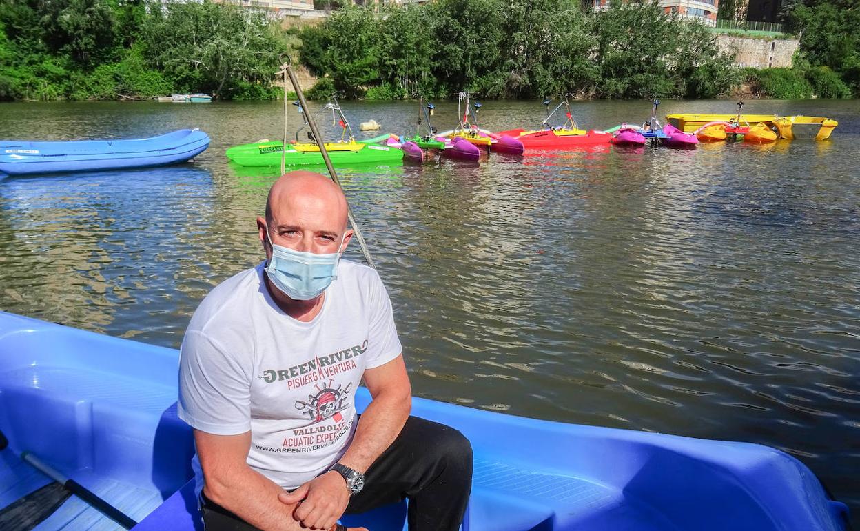 Javier Marqués posa en una de sus barcas de alquiler ante su flotilla de hidrobicis y embarcaciones.