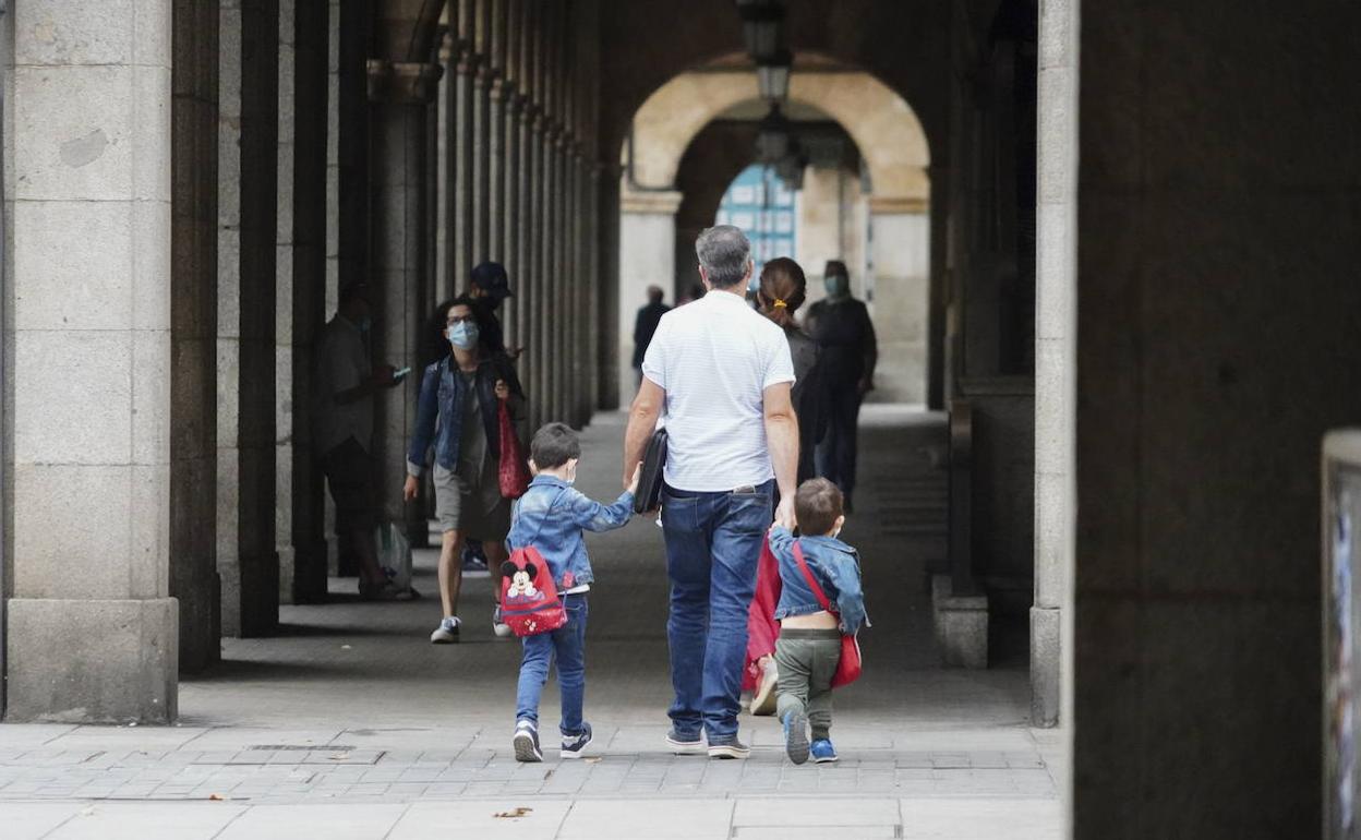 Un padre lleva a sus hijos al colegio.