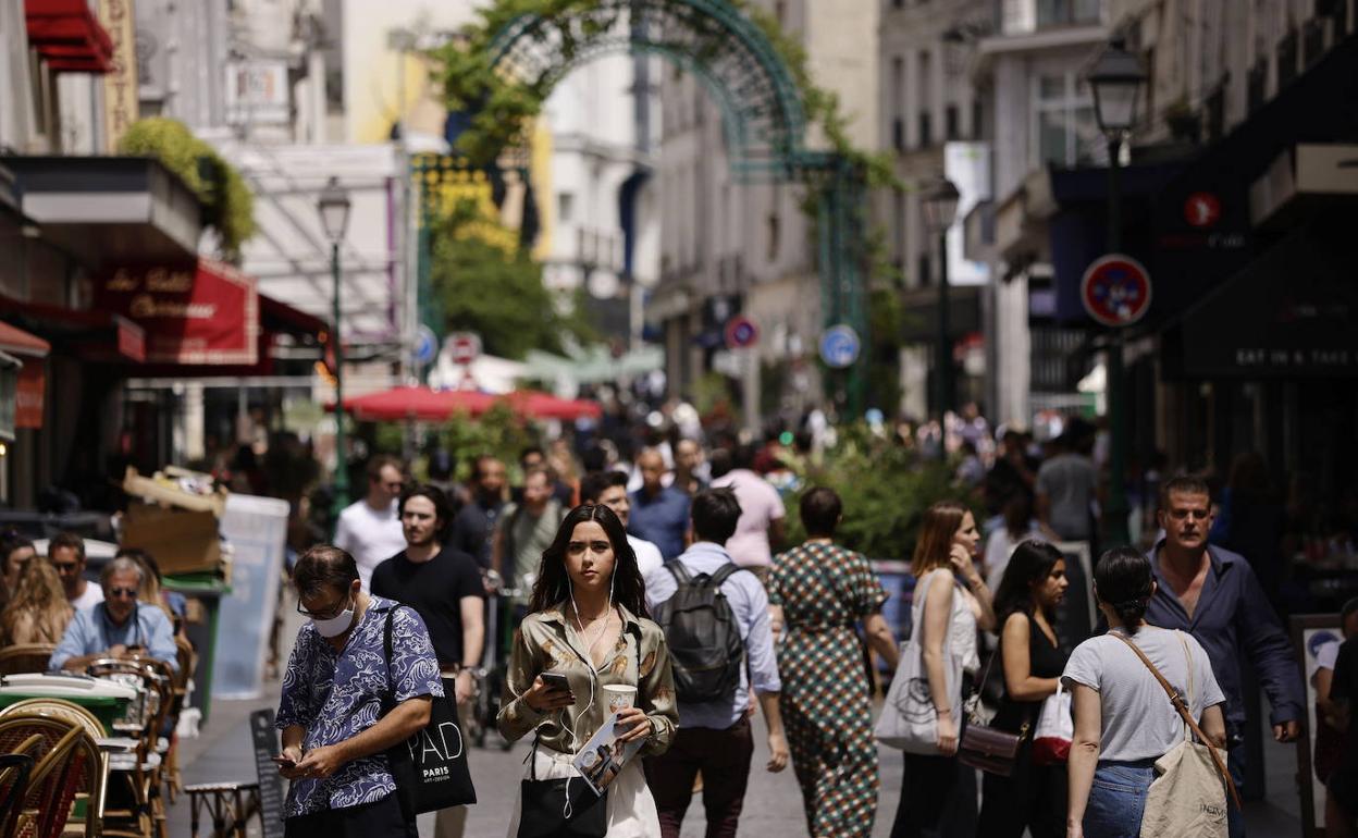 Una calle donde conviven personas con mascarillas y sin ellas.