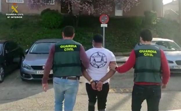 Dos agentes de la Guardia Civil conducen a uno de los detenidos.