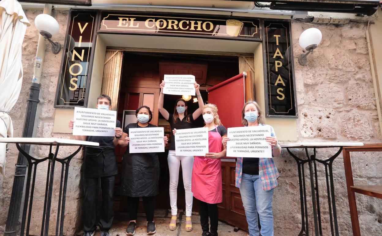 El equipo y la dirección de El Corcho muestran los carteles a las puertas del local. 