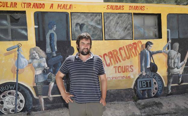 Eduardo Perote posa en Piñel de Abajo ante el mural que representa al 'Autobús de la Despoblación'.