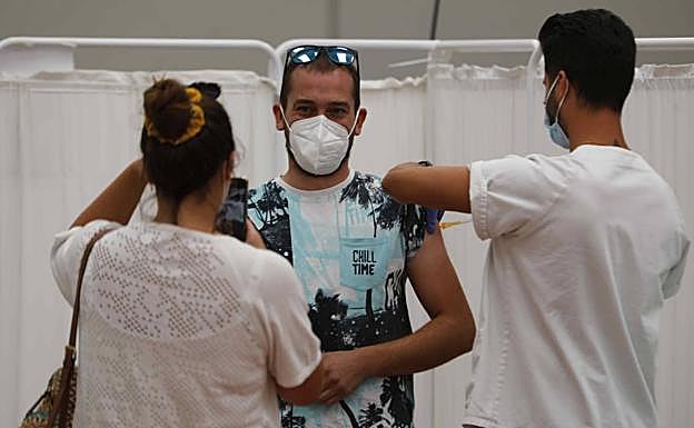 Una chica retrata con el móvil el momento en que un joven recibe la vacuna en Peñafiel. 