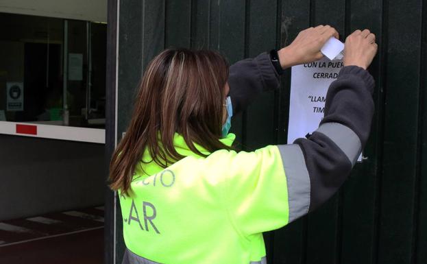 Una trabajadora cuelga el cartel del cierre del aparcamiento el pasado otoño. 