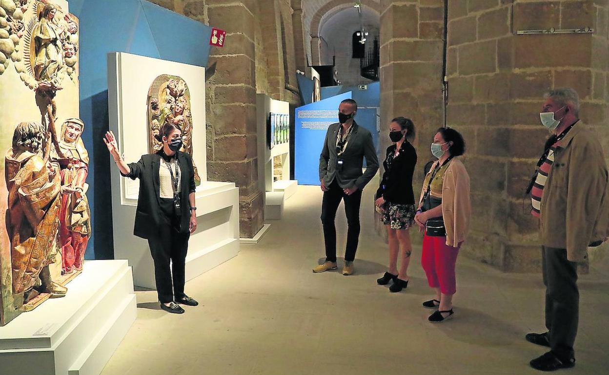 Una guía explica uno de los conjuntos escultóricos en la iglesia de Santa María del Camino.