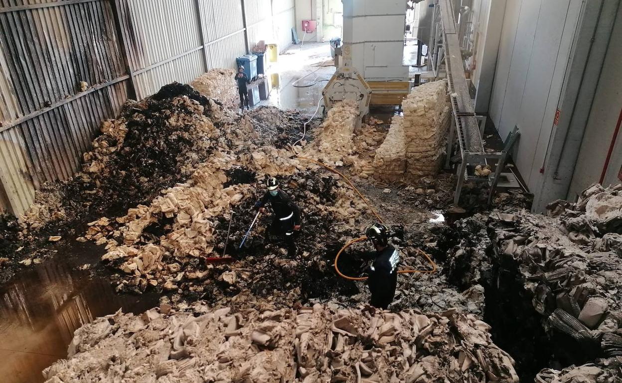 Los Bomberos, durante el enfriamiento del material calcinado por el fuego. 