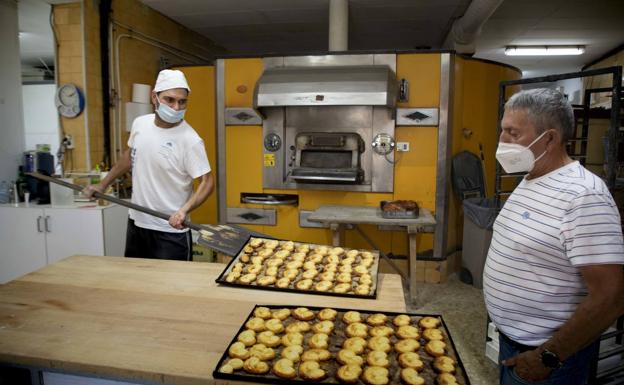 David y su padre Teodoro Laguna sacan bandejas de palmeras del horno en su panadería de Villalar de los Comuneros. 