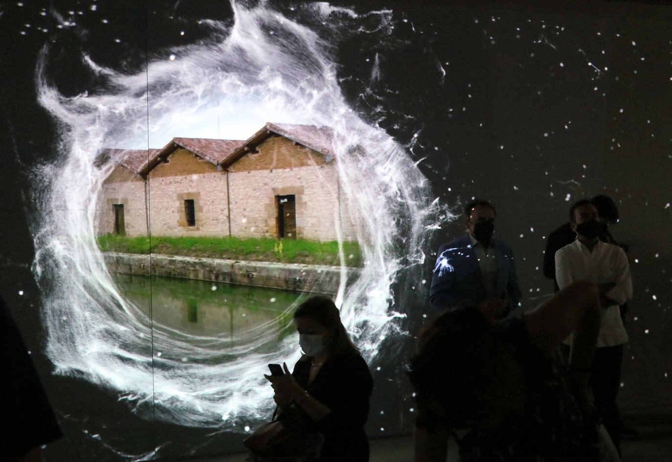 Los asistentes a la inauguración contemplan una de las proyecciones. 