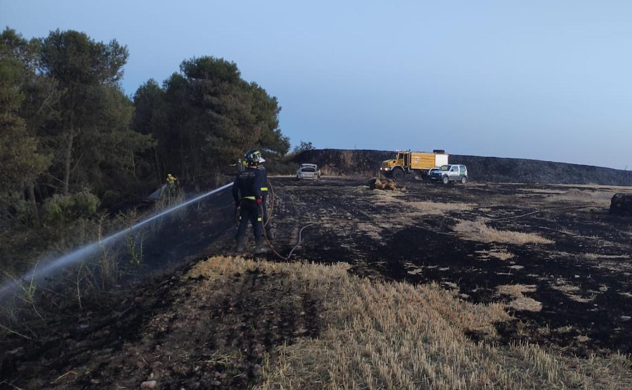 Rastrojos quemados por el incendio provocado por la banda del BMW para acabar con un vehículo (al fondo) en Ciguñuela. 