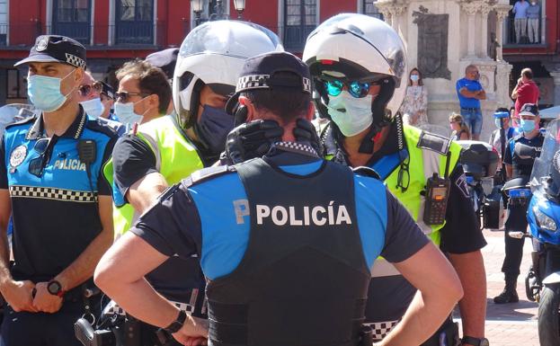 Dos agentes consuelan a un compañero de la víctima. 