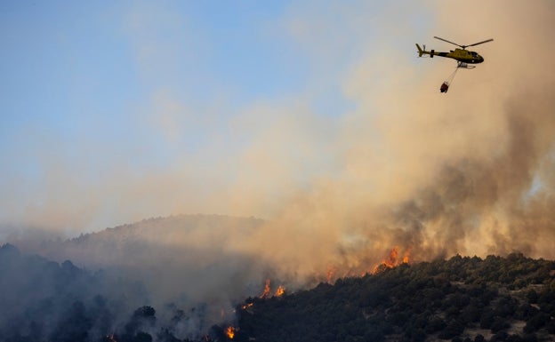 Un helicóptero trabaja en las labores de extinción del fuego de El Tiemblo.