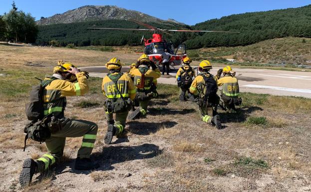 Efectivos de la BRIF de Puerto el Pico frente al helicóptero que trabaja en la zona del incendio de El Tiemblo. 