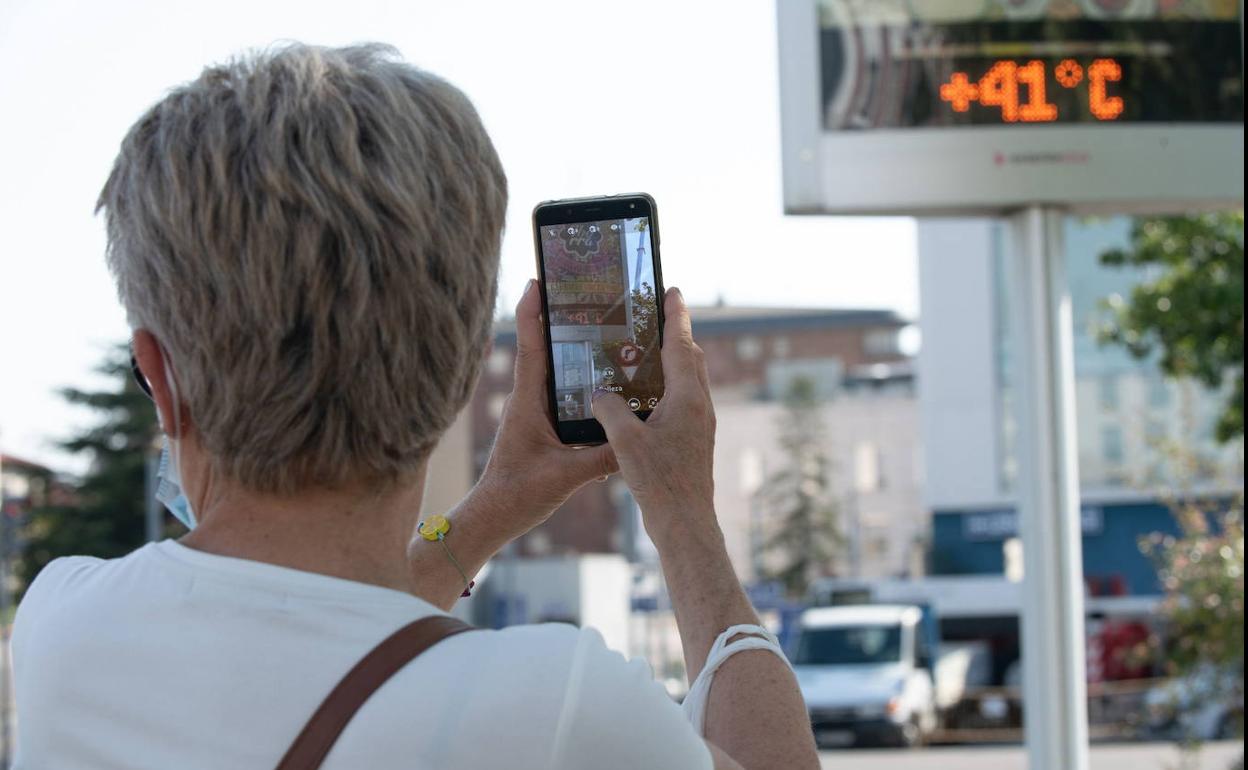 Una mujer fotografía un termómetro de Valladolid que muestra 41 grados durante el mes de julio de 2020.