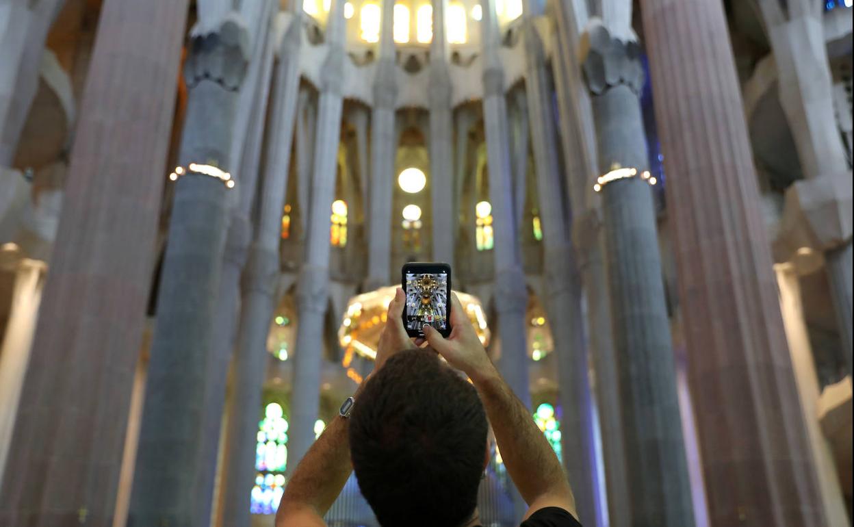 Un turista fotografía el interior de la Sagrada Familia de Barcelona.