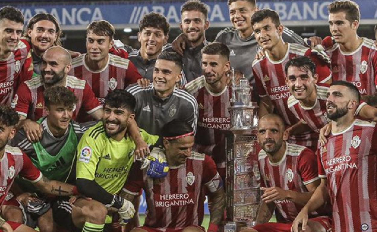 La plantilla 21-22 de la Ponferradina posa con el prestigioso Trofeo Teresa Herrera sobre el césped de Riazor.