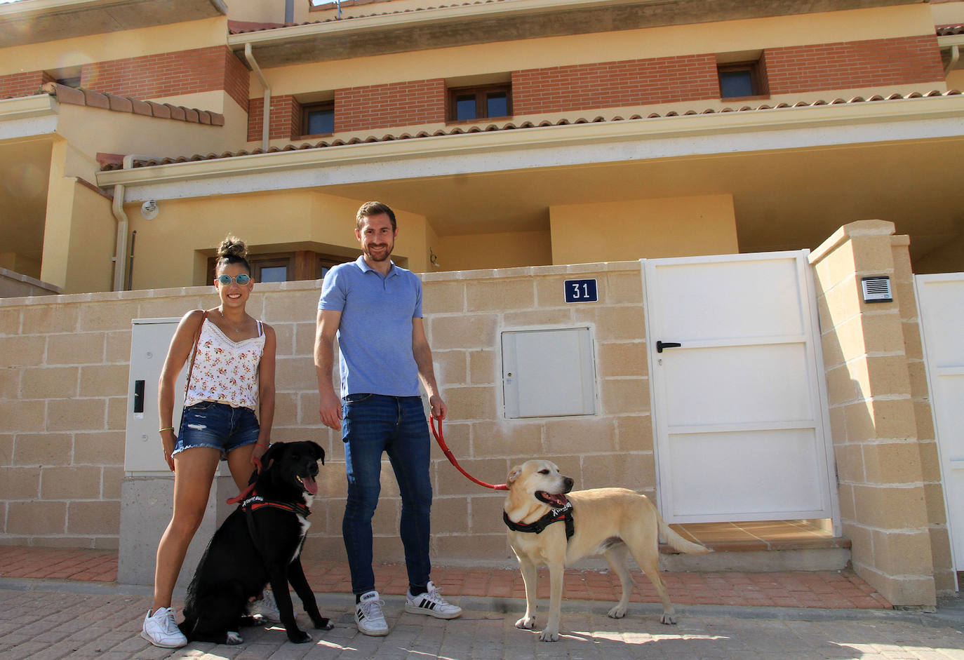 Helena y Daniel, con sus perros, delante de la casa en la que vivirán en breve. 