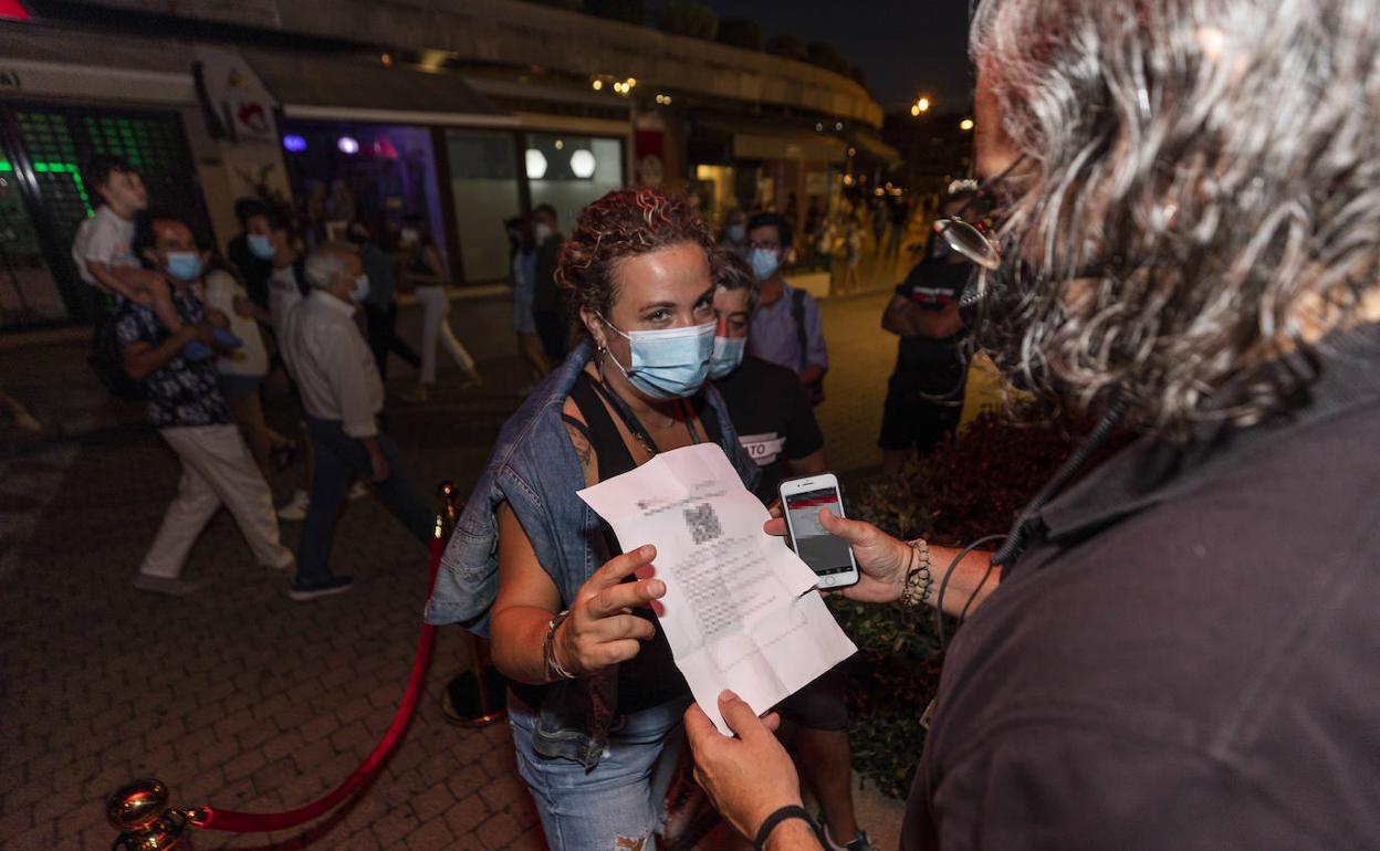 Una joven muestra un codigo QR en un bar de Sanxenxo.