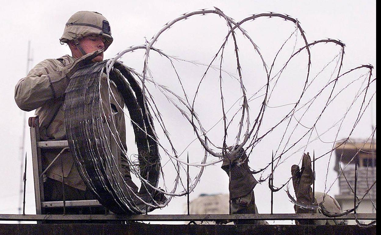 Un soldado estadounidense protege con una alambrada los muros de la Embajada de EE UU en Kabul, en una imagen de archivo.