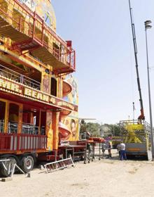 Imagen secundaria 2 - Los feriantes han comenzado el montaje de sus atracciones en el Real de la Feria. Arriba, Laura y su hijo Erik ponen a punto su puesto Premiolandia. Debajo, el bngo de Miguel Ángel Esgueva y Mister Bean. JOSÉ C. CASTILLO