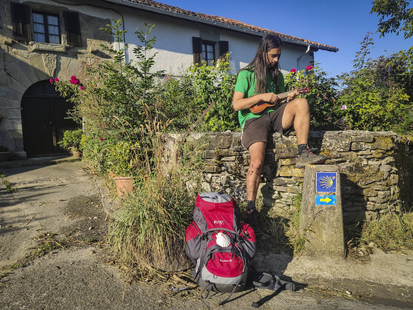 Pasado Larrasoaña, en Akerreta, Pau se detiene a tocar su ukelele junto a un caserío. A sus pies la flecha amarilla, compañero inseparable de los peregrinos en su ruta a Santiago.