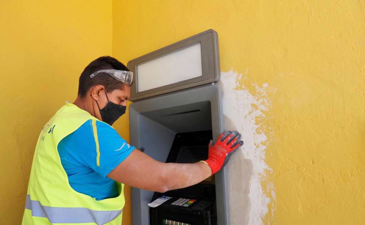Un operario encastra uno de los cajeros que la Diputación de Valladolid ha instalado en la provincia. 