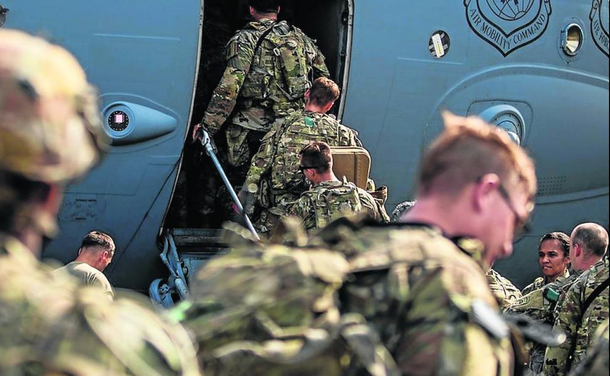 Soldados estadounidenses subiendo a un avión de transporte.