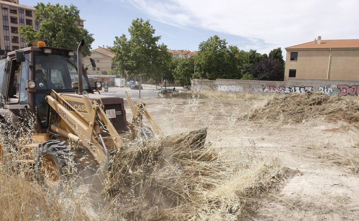 Una excavadora limpia un solar.