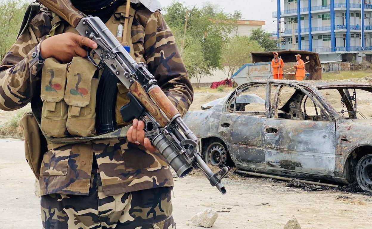 Los talibanes montan guardia cerca de un vehículo que se utilizó para disparar cohetes en el aeropuerto internacional Hamid Karzai en Kabul.