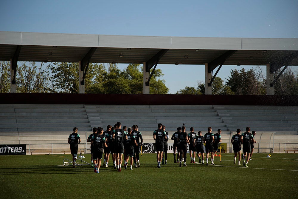 Los jugadores entrenan a las órdenes de Dani Mori mientras los voluntarios del club preparan las gradas del Reina Sofía