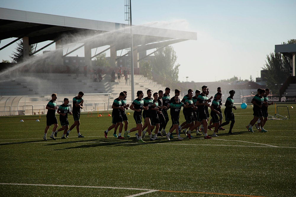 Los jugadores entrenan a las órdenes de Dani Mori mientras los voluntarios del club preparan las gradas del Reina Sofía