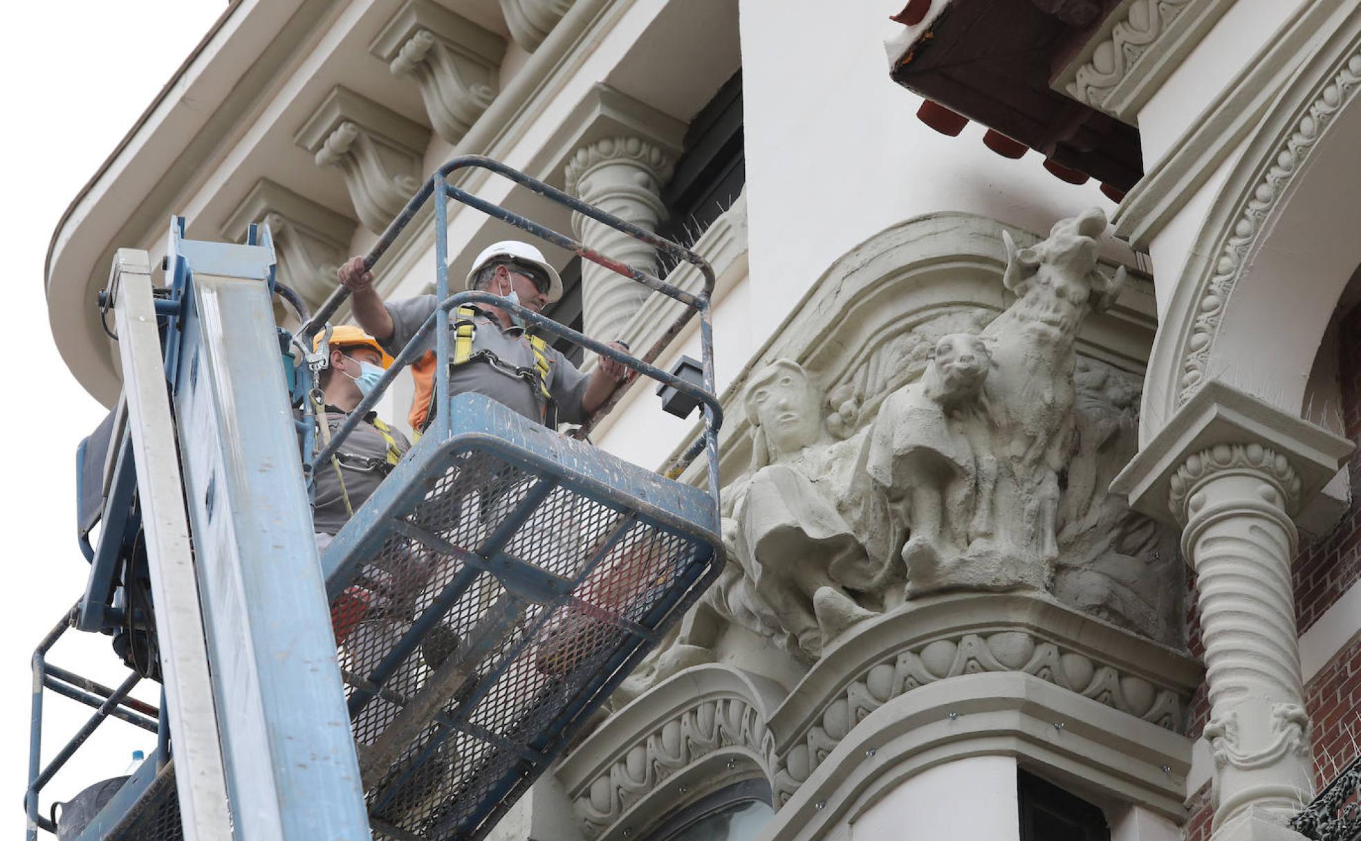 Dos operararios observan este miércoles el Ecce Homo sobre una grúa elevadora. 