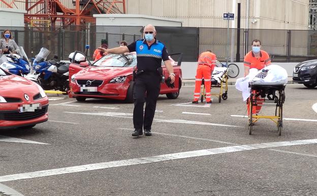 El primero de los heridos sale en camilla del coche hacia la ambulancia.