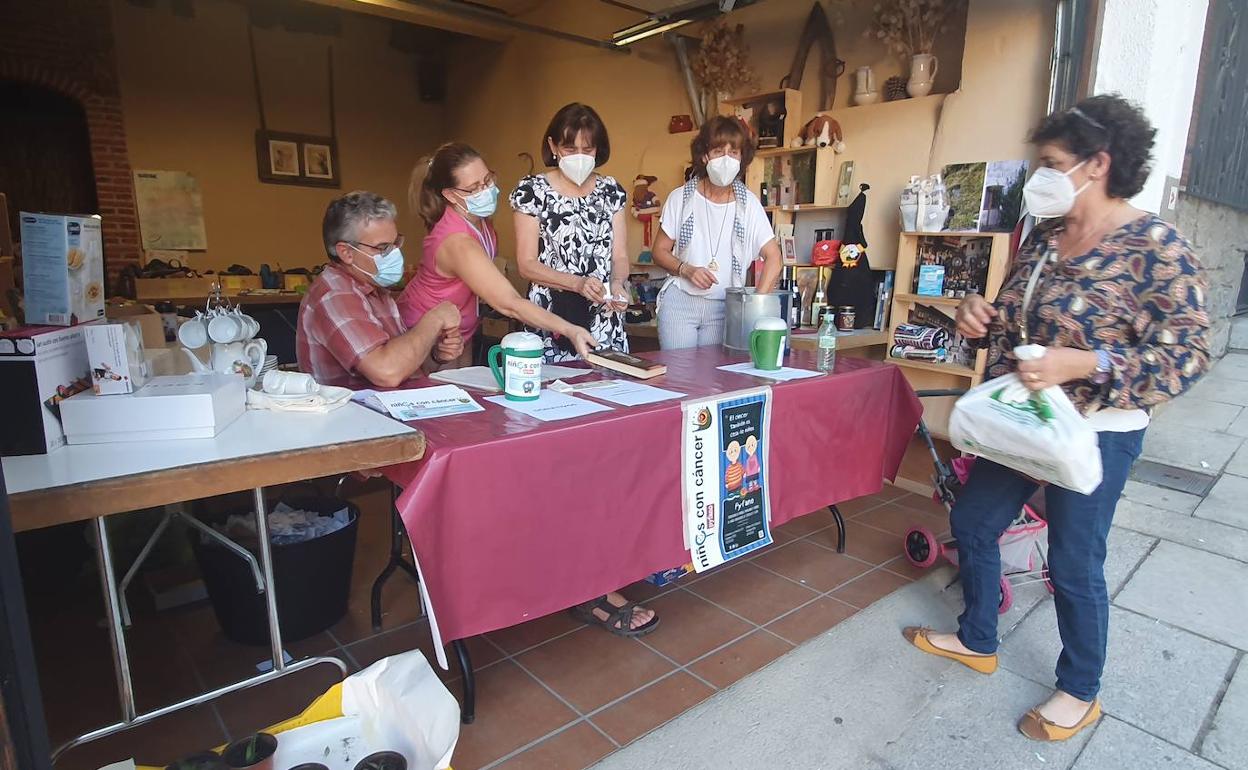 Una vecina recogiendo un libro que le había tocado en la tómbola solidaria a favor de Pyfano. 